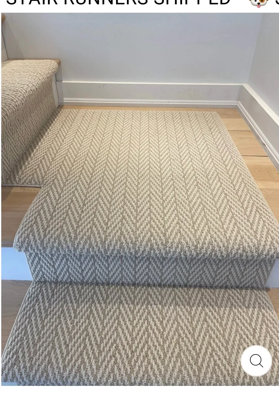 Herringbone patterned carpet stair runners with white trim on wooden stairs